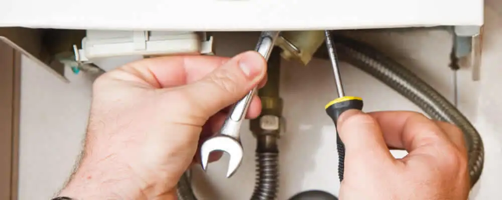 Boiler repair technician tightening pipe fittings and connections in Durham, NC