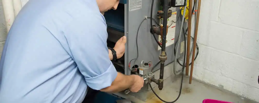 Furnace repair technician inspecting and servicing a home heating system in Durham, NC