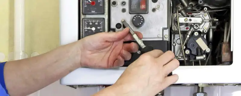 Heating repair technician adjusting boiler controls and components in Durham, NC