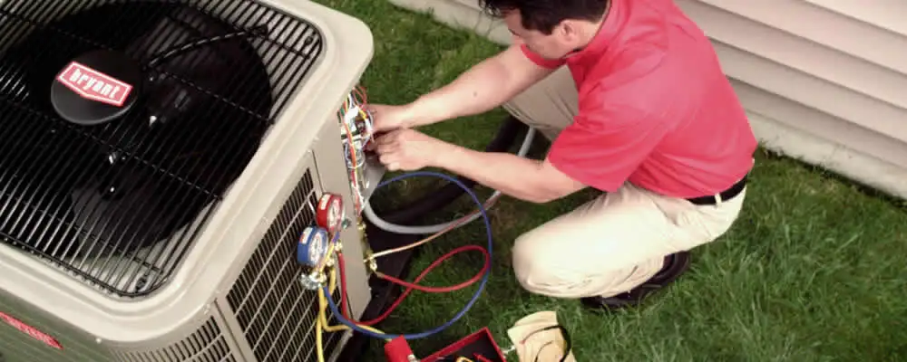 HVAC technician servicing an outdoor air conditioner unit in Durham, NC