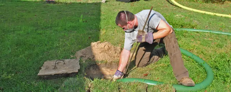 Septic pumping technician servicing a residential septic tank in Durham, NC