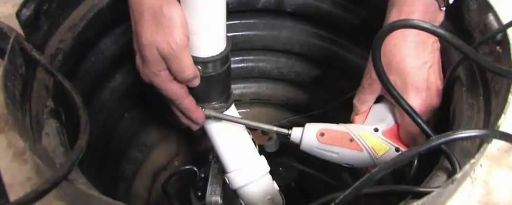 Sump pump installation technician connecting PVC discharge piping in Durham, NC